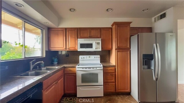 28821 Del Monte Dr, Menifee, CA 92586 - kitchen with white appliances, brown cabinets, decorative backsplash, recessed lighting, and dark countertops