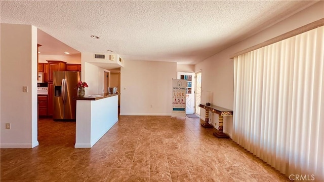 28821 Del Monte Dr, Menifee, CA 92586 - kitchen featuring stainless steel fridge with ice dispenser, a textured ceiling, white microwave, recessed lighting, and brown cabinets