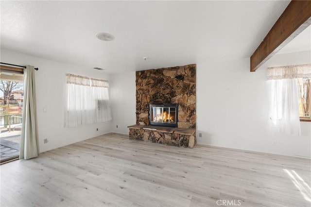 13615 Spring Valley Pkwy, Victorville, CA 92395 - unfurnished living room with beam ceiling, visible vents, a fireplace, and wood finished floors