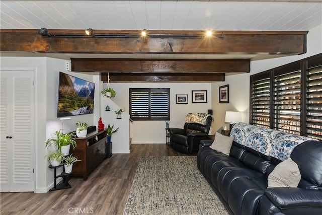 living area with beam ceiling, baseboards, and wood finished floors