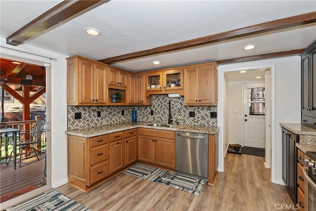 kitchen with appliances with stainless steel finishes, a sink, light wood-style flooring, and beamed ceiling