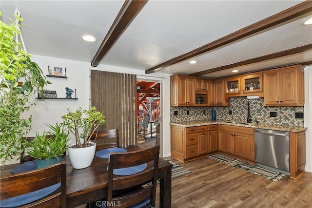 kitchen with backsplash, dark wood-type flooring, beam ceiling, stainless steel dishwasher, and a sink