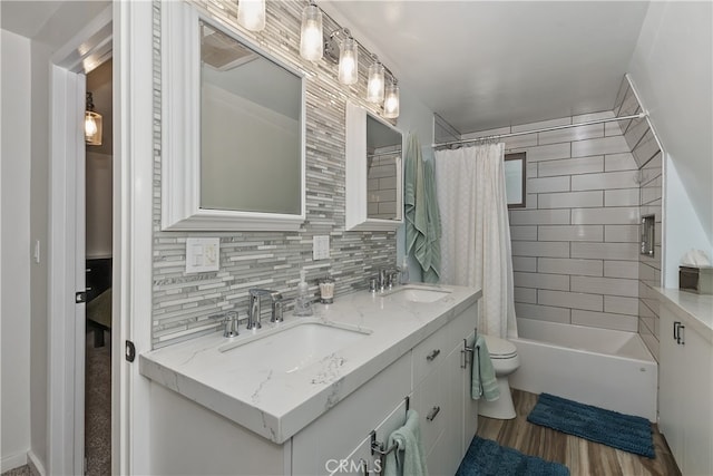 full bath featuring wood finished floors, a sink, toilet, and decorative backsplash