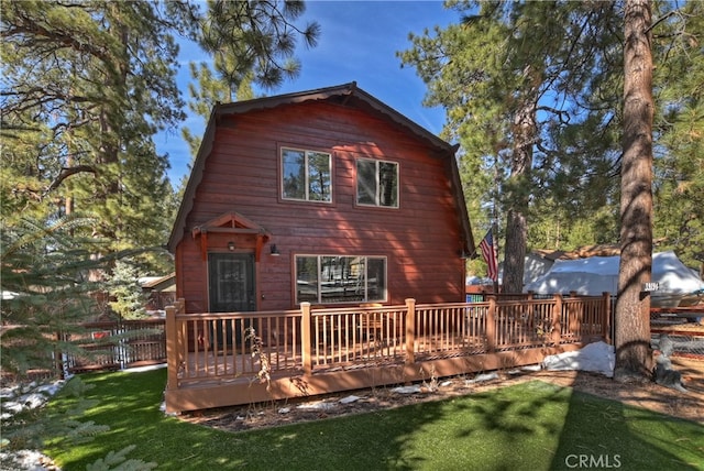 back of house featuring a yard, a deck, and fence