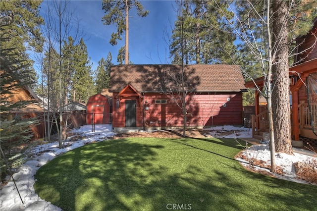 view of front of property featuring a shingled roof, a front yard, and fence