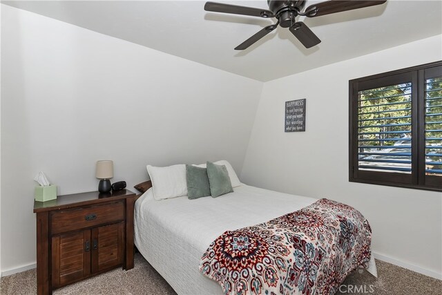 bedroom with light carpet, a ceiling fan, and baseboards