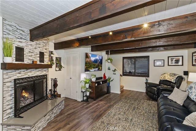 living area featuring a large fireplace, beam ceiling, baseboards, and wood finished floors