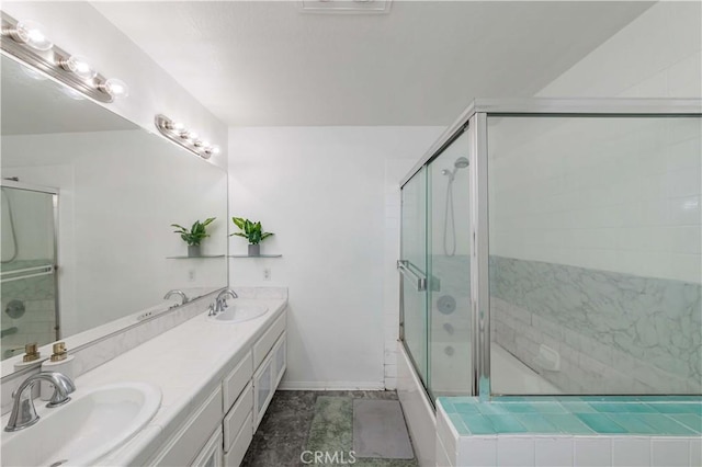 full bath with double vanity, combined bath / shower with glass door, a sink, and baseboards