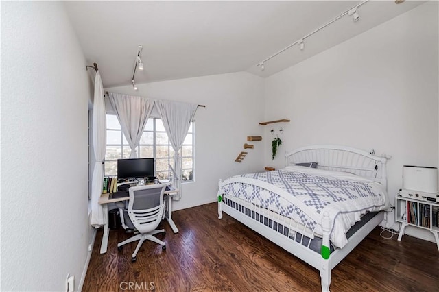 bedroom with lofted ceiling, rail lighting, and wood finished floors