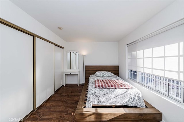 bedroom featuring a closet and dark wood-style flooring