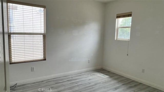 empty room featuring baseboards and wood finished floors