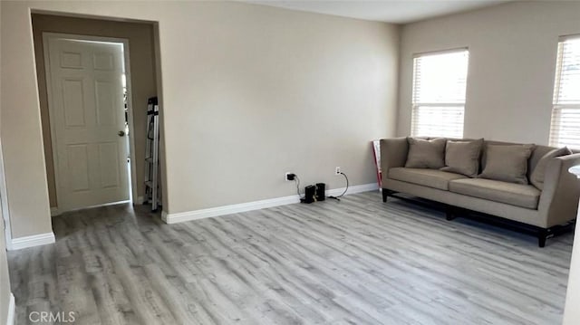 unfurnished living room featuring baseboards and wood finished floors