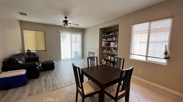 dining area with light tile patterned floors, baseboards, visible vents, built in features, and ceiling fan