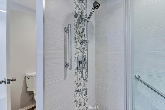 full bathroom featuring toilet and a tile shower