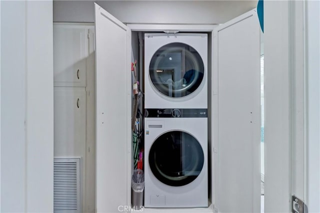 laundry area featuring visible vents, laundry area, and stacked washer and clothes dryer