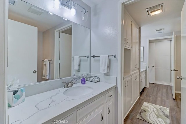 bathroom featuring visible vents, wood finished floors, and vanity