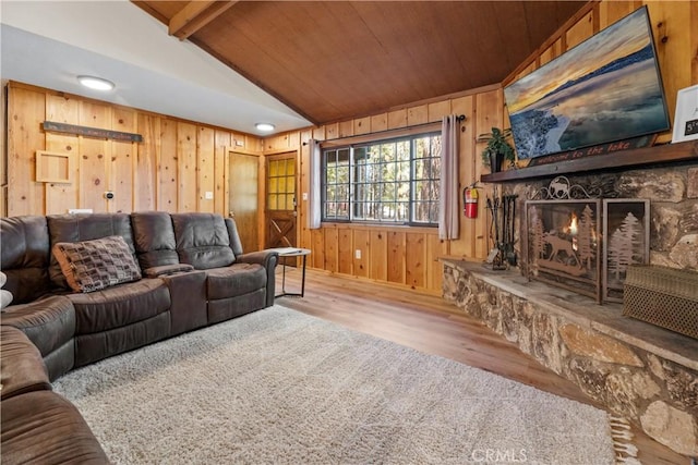 living area with a fireplace, vaulted ceiling with beams, wood ceiling, wood walls, and wood finished floors