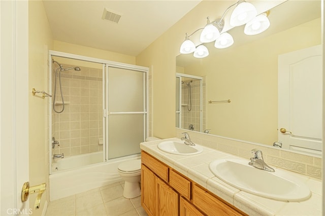 bathroom with toilet, visible vents, a sink, and tile patterned floors