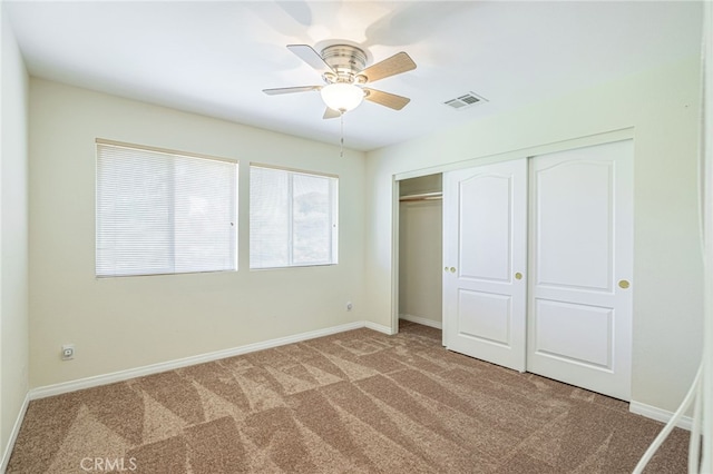 unfurnished bedroom featuring a closet, carpet flooring, visible vents, and baseboards