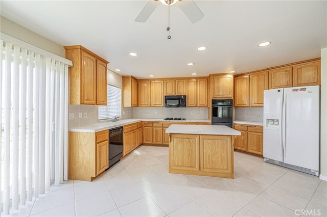 kitchen featuring decorative backsplash, a kitchen island, tile countertops, and black appliances