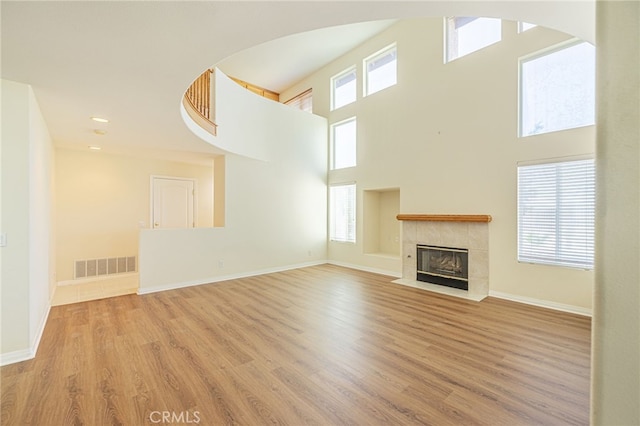 unfurnished living room with plenty of natural light, wood finished floors, and visible vents