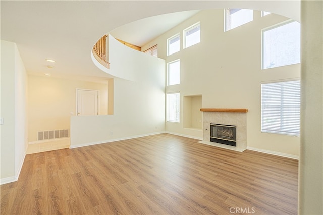 41445 Terrazzo Dr, Palmdale, CA 93551 - unfurnished living room featuring a fireplace, wood finished floors, baseboards, a high ceiling, and recessed lighting