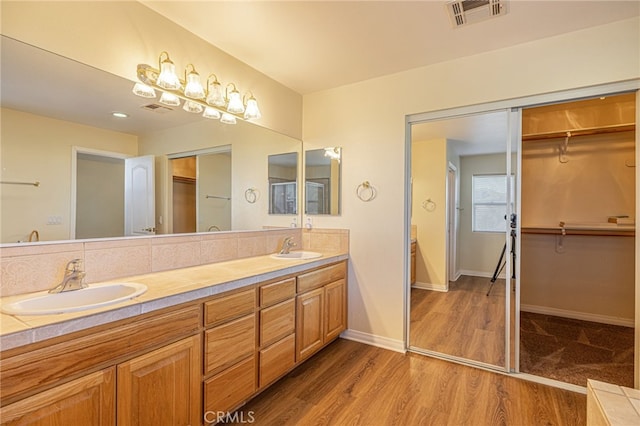 41445 Terrazzo Dr, Palmdale, CA 93551 - bathroom with double vanity, a walk in closet, wood finished floors, and baseboards