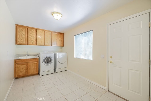 laundry area with baseboards, a sink, cabinet space, and washer and dryer