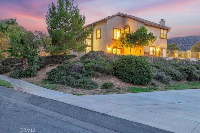 view of front of house featuring a chimney and stucco siding