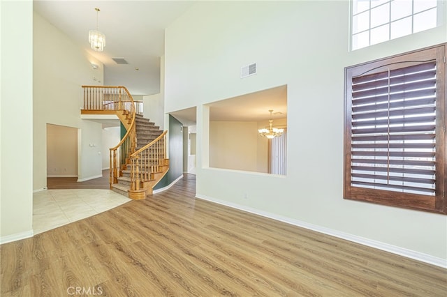 41445 Terrazzo Dr, Palmdale, CA 93551 - foyer with a high ceiling, a chandelier, wood finished floors, stairway, and baseboards