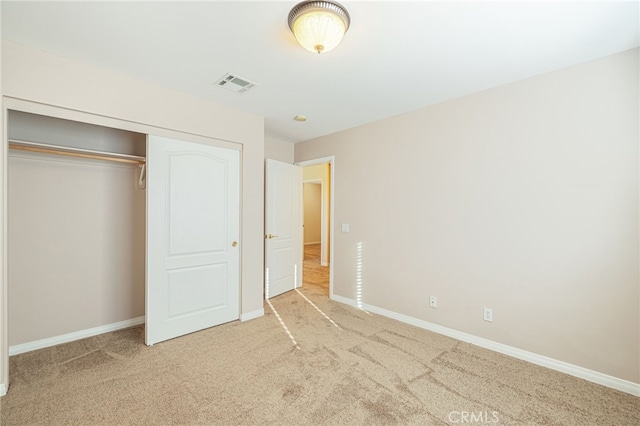 unfurnished bedroom with carpet floors, a closet, visible vents, and baseboards