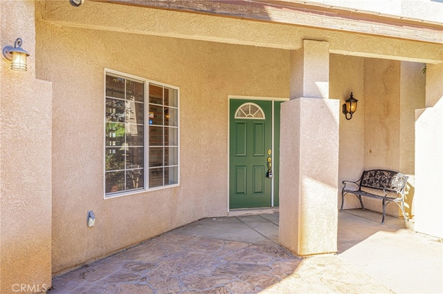 doorway to property featuring stucco siding