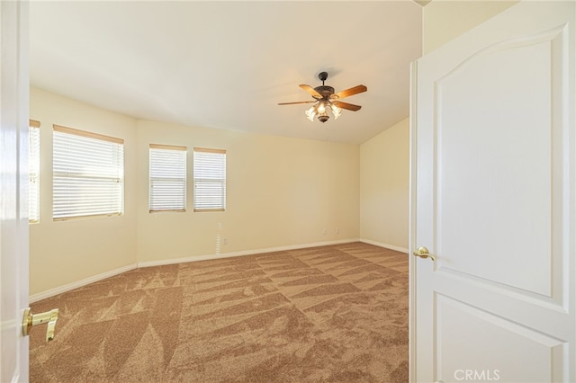 carpeted empty room featuring ceiling fan and baseboards