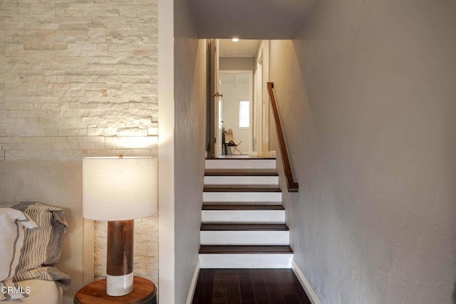 staircase featuring baseboards and wood finished floors