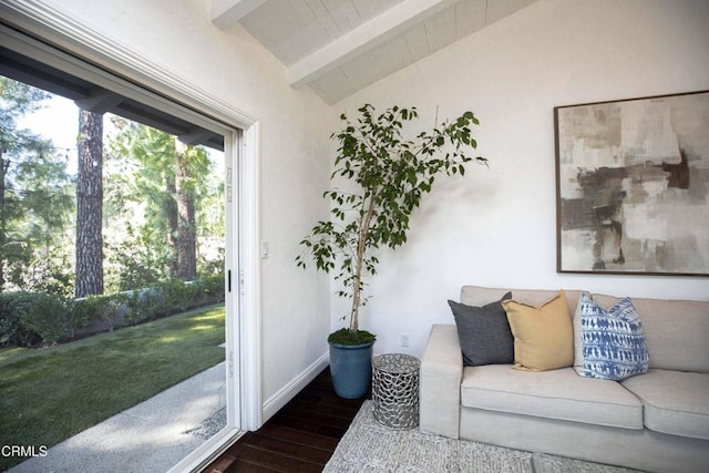 living area with vaulted ceiling with beams, wood finished floors, and baseboards