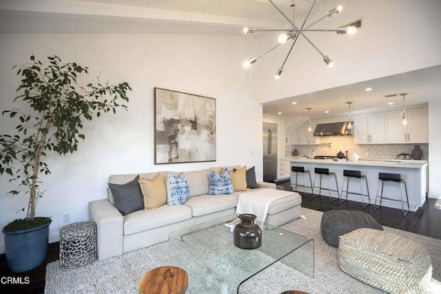 living room featuring a chandelier, dark wood finished floors, and lofted ceiling with beams