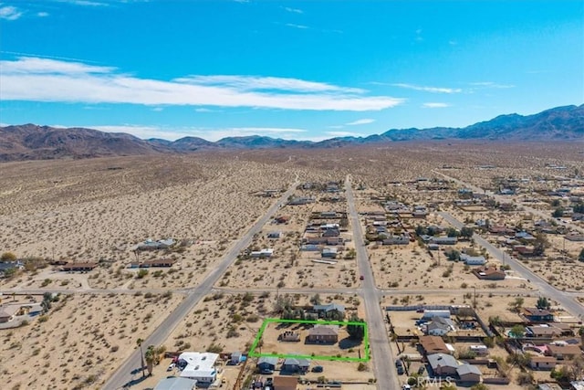 drone / aerial view featuring a mountain view and a desert view