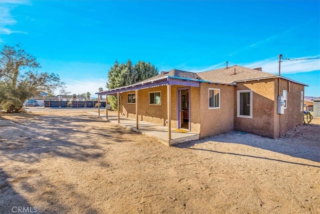 view of home's exterior featuring a patio area, fence, and stucco siding