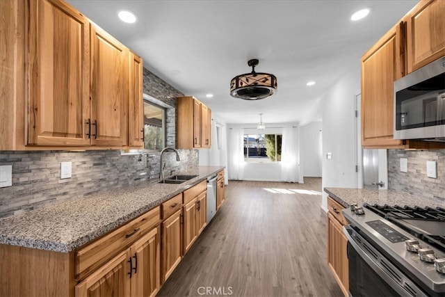 kitchen with recessed lighting, backsplash, appliances with stainless steel finishes, dark wood-type flooring, and a sink