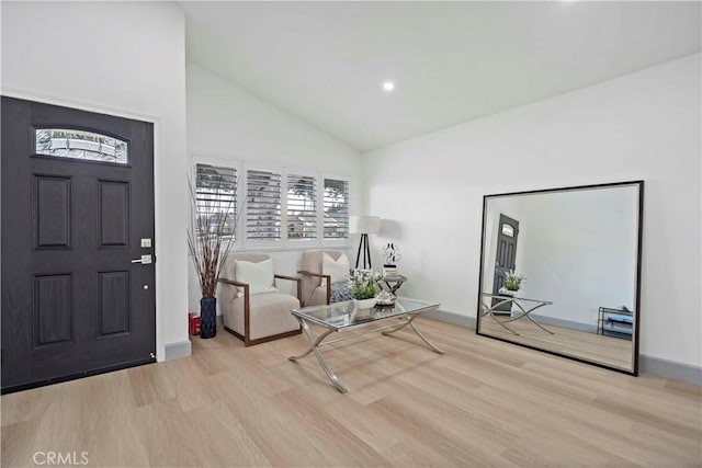 entrance foyer featuring high vaulted ceiling, baseboards, and wood finished floors