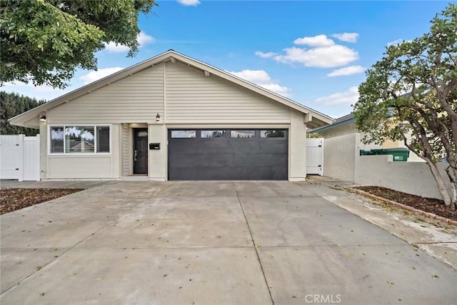 ranch-style home with a garage, a gate, driveway, and fence