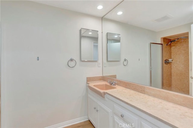 full bathroom featuring a shower, recessed lighting, vanity, and baseboards