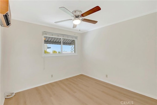 spare room featuring baseboards, ornamental molding, a ceiling fan, and light wood-style floors