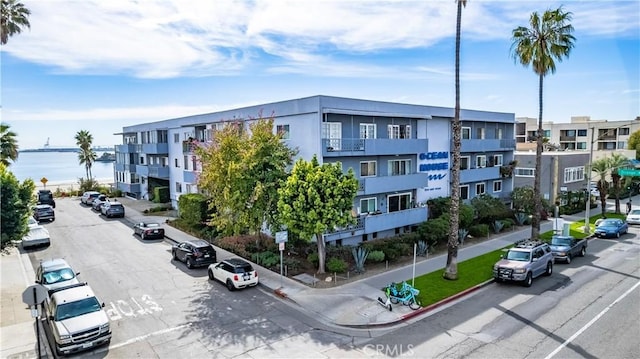 view of building exterior with a water view and uncovered parking