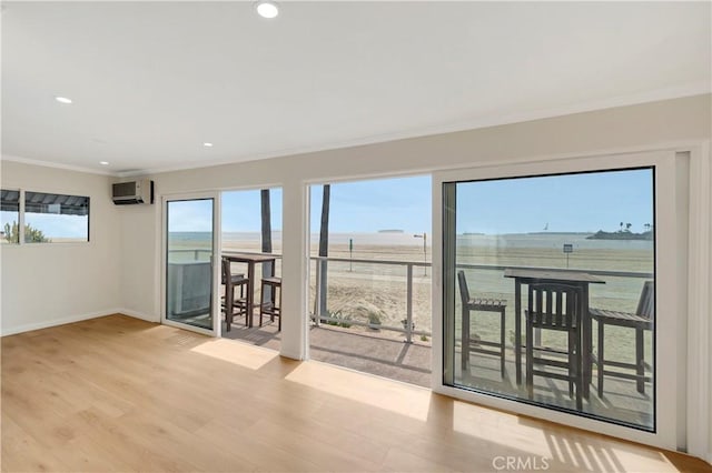 interior space with plenty of natural light, baseboards, crown molding, and wood finished floors