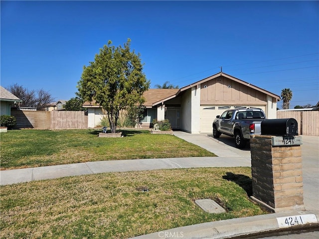 view of front facade with an attached garage, fence, driveway, board and batten siding, and a front yard