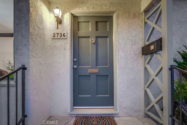 view of exterior entry with stucco siding