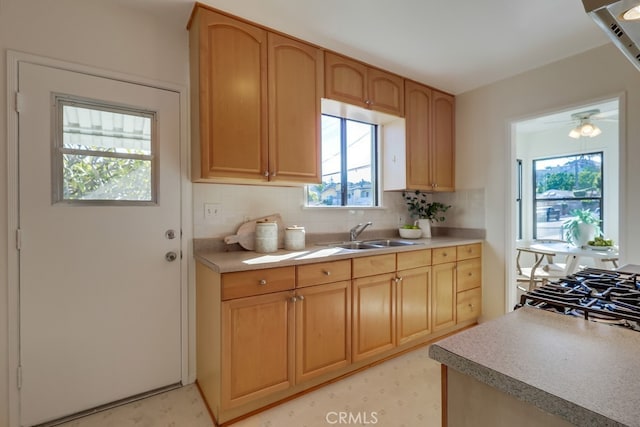 kitchen featuring light floors, light countertops, a sink, and decorative backsplash