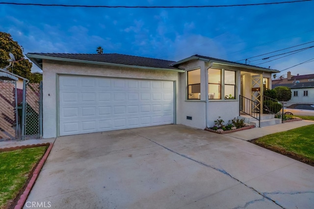 ranch-style house with a garage, concrete driveway, fence, and stucco siding