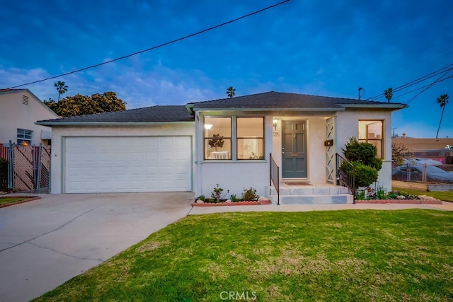 view of front facade with a front yard, concrete driveway, an attached garage, and stucco siding